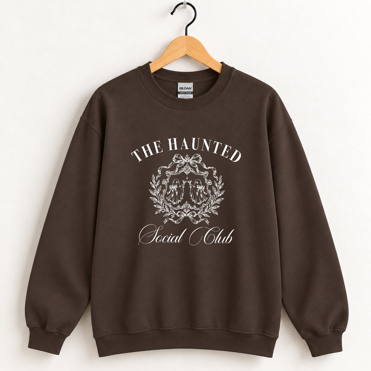 The Haunted Social Club crewneck sweatshirt in Dark Chocolate on a wooden hanger