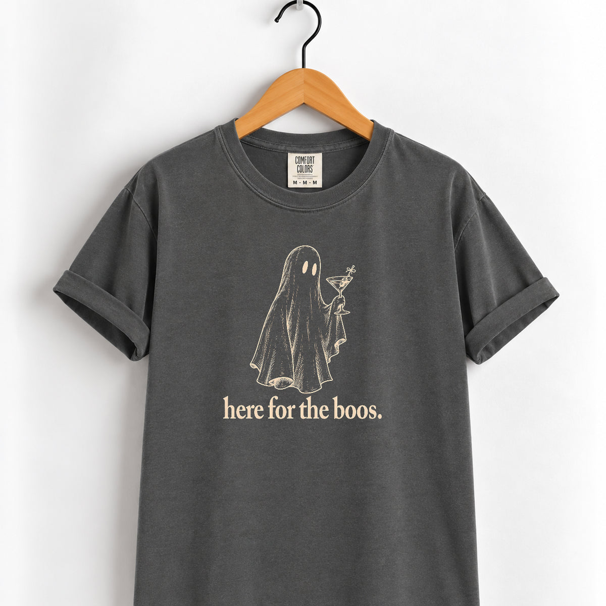 Here for the Boos tee in Pepper on a wooden hanger, cream ghost holding a martini with the words here for the boos