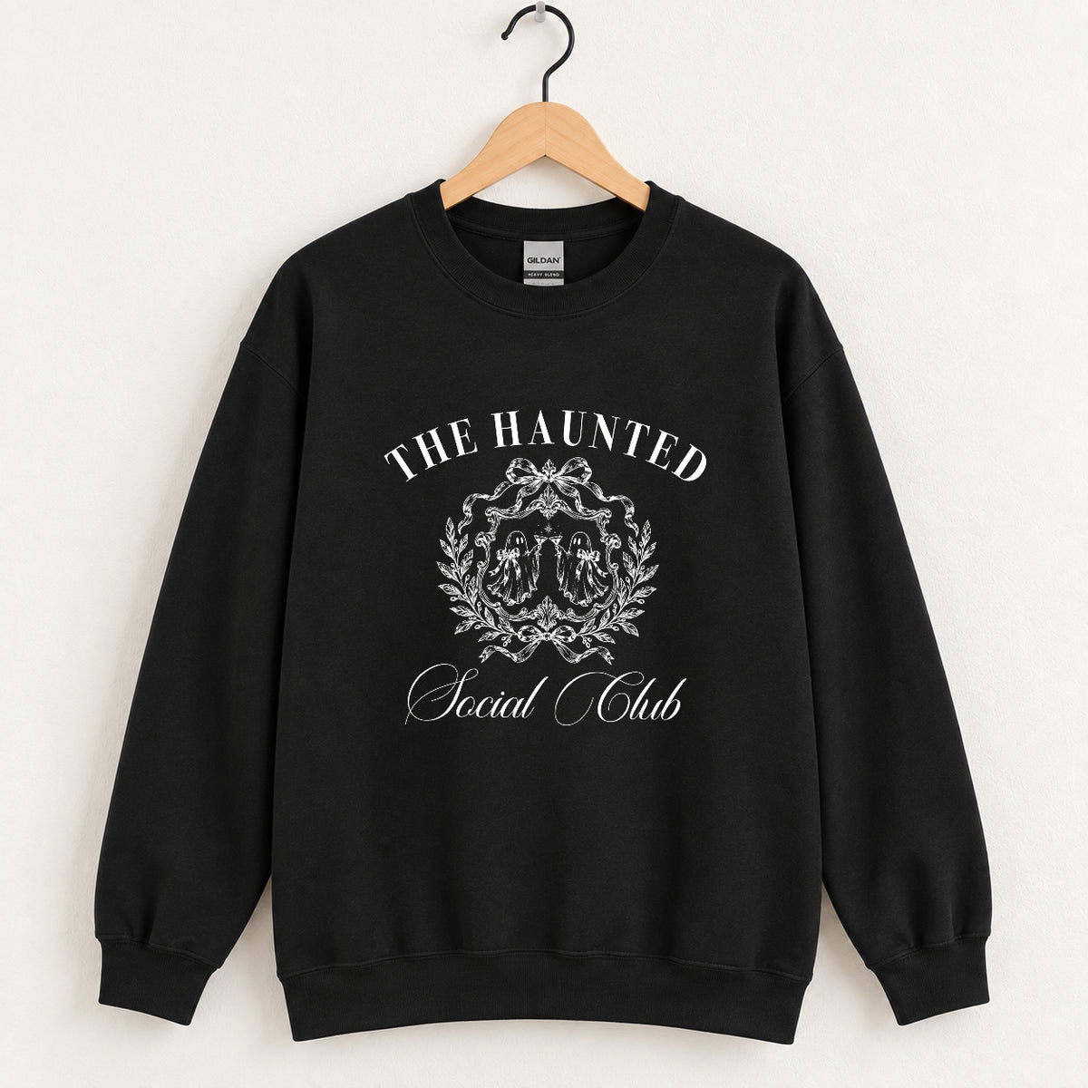 The Haunted Social Club crewneck sweatshirt in Black on a wooden hanger, off-white ghost crest on the chest