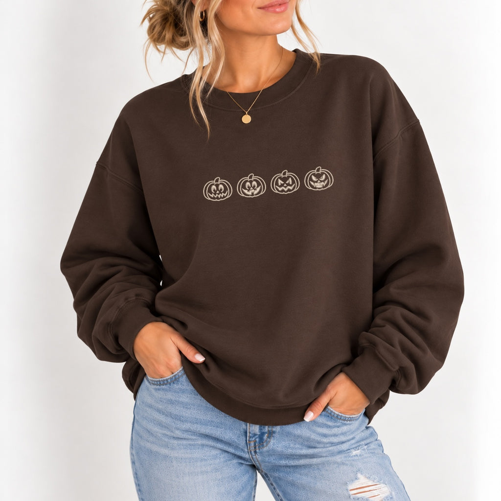 Woman wearing the jack-o-lantern embroidered crewneck sweatshirt in Dark Chocolate with jeans