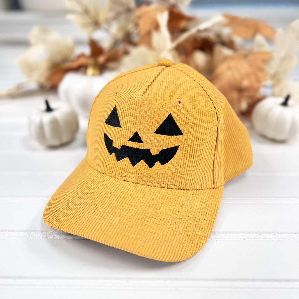 Jack-o-lantern embroidered corduroy snapback hat in Golden Amber with a black thread pumpkin face