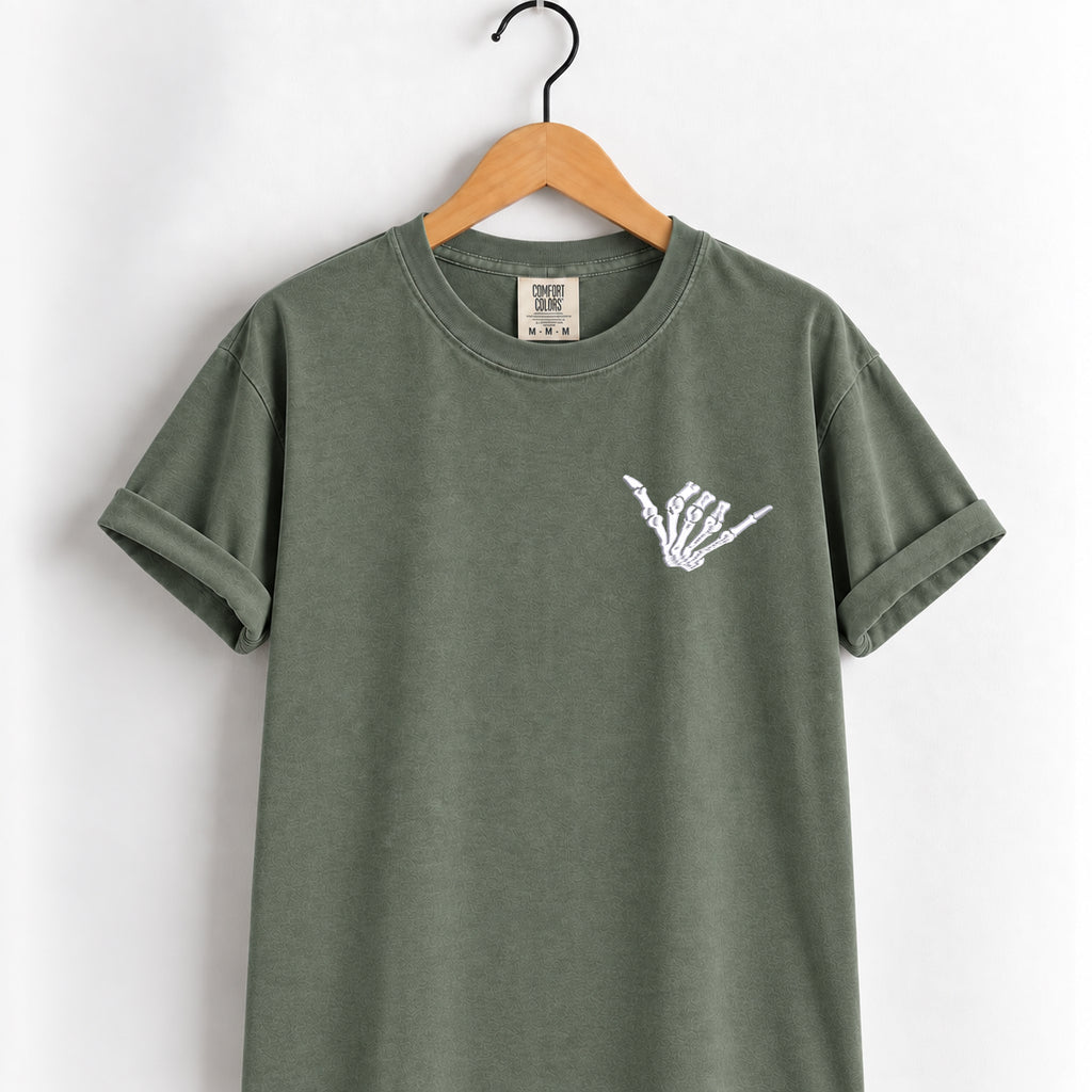 Shaka skeleton hand embroidered tee in Moss on a wooden hanger