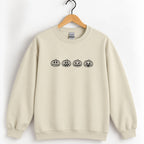 Jack-o-lantern embroidered crewneck sweatshirt in Sand on a wooden hanger, black thread pumpkins