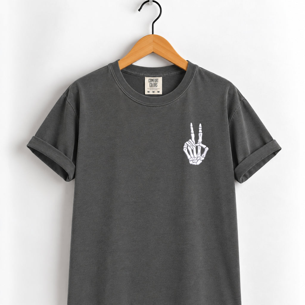 Peace sign skeleton hand embroidered tee in Pepper on a wooden hanger