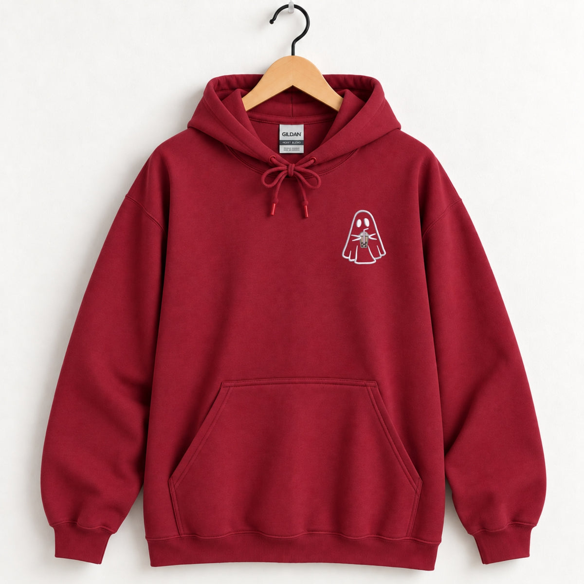 Ghost with a drink embroidered hoodie in Cardinal Red on a wooden hanger