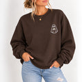Woman wearing the ghost with a drink embroidered crewneck sweatshirt in Dark Chocolate with jeans