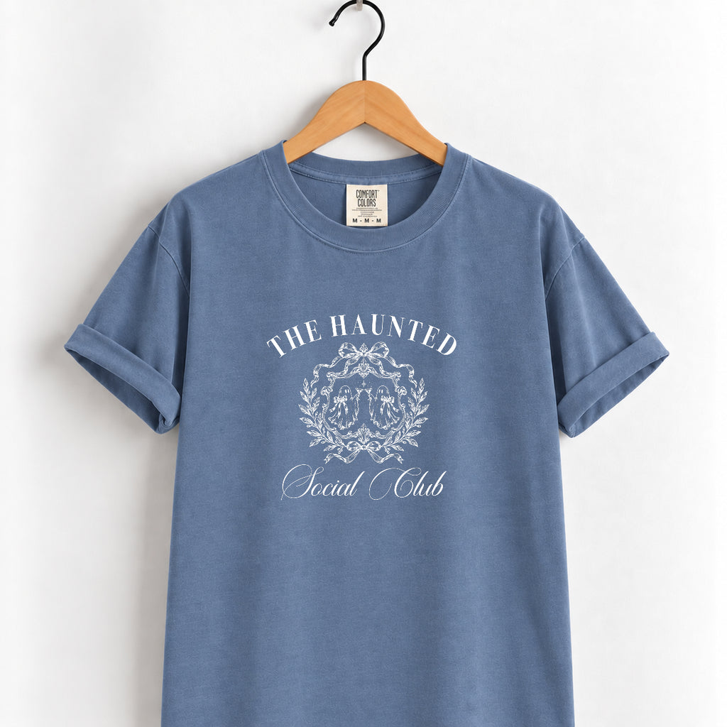 The Haunted Social Club tee in Blue Jean on a wooden hanger