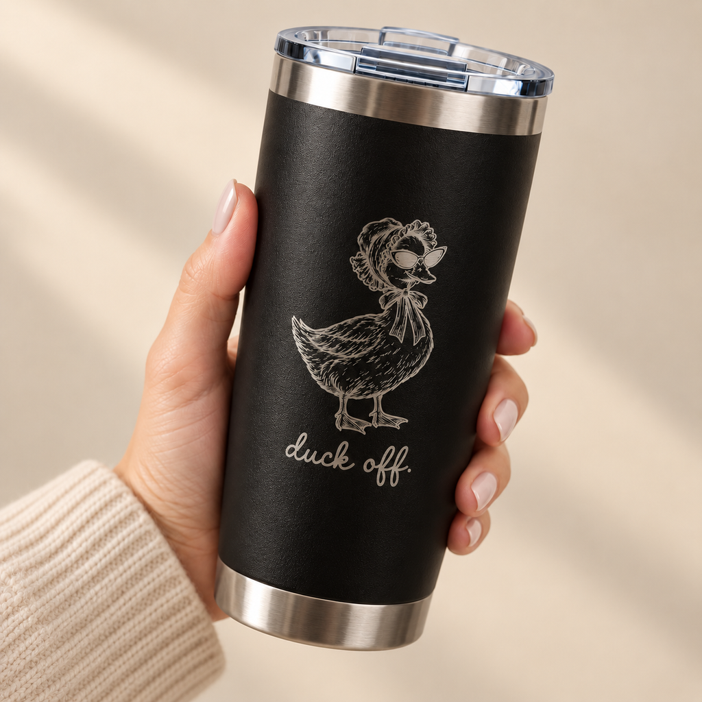 Hand holding the Duck Off engraved 20 oz tumbler in Black, silver engraved duck in a bonnet
