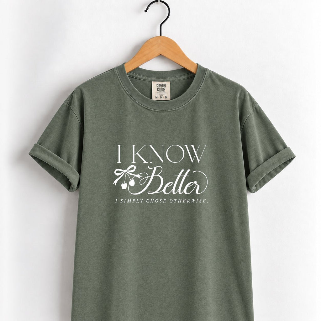 I Know Better, I Simply Chose Otherwise Comfort Colors tee in Moss on a wooden hanger, front view