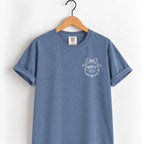Raised Better Than This crest tee in Blue Jean on a wooden hanger, left-chest RBTT logo with bow