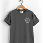 Raised Better Than This crest tee in Pepper on a wooden hanger, left-chest RBTT logo with bow