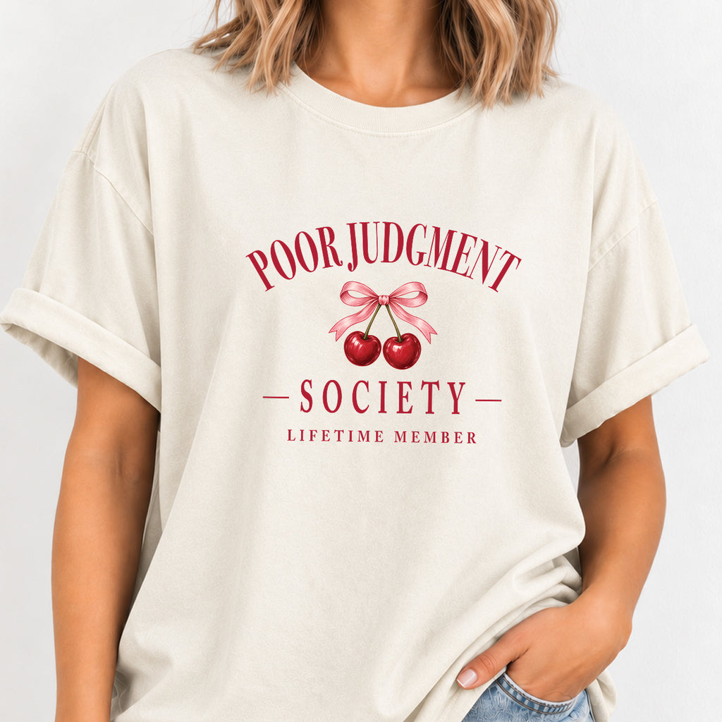 Woman wearing the Poor Judgment Society Lifetime Member tee in Ivory with deep red lettering