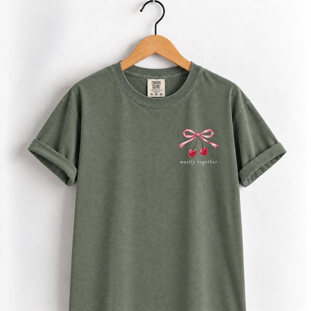 Mostly Together cherry bow tee in Moss on a wooden hanger