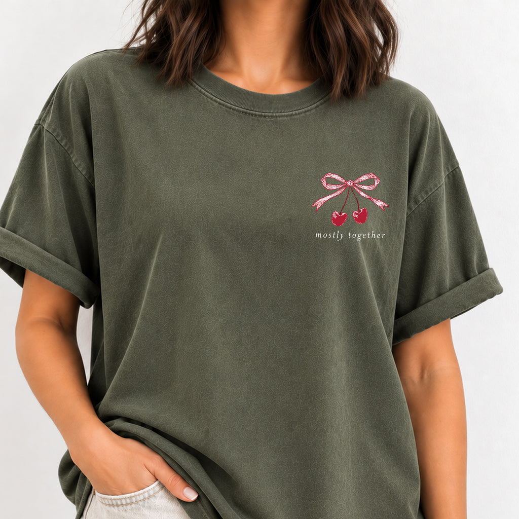 Woman wearing the Mostly Together cherry bow tee in Moss