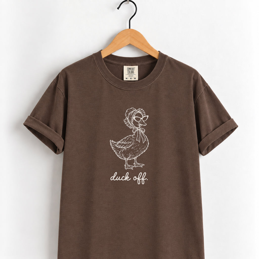 Duck Off tee in Espresso on a wooden hanger, off-white duck design center chest